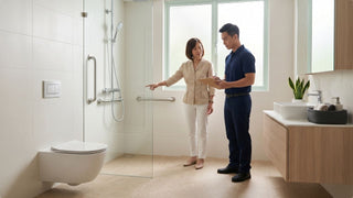 Homeowner reviewing grab bar placement with a contractor in a bright accessible Singapore bathroom