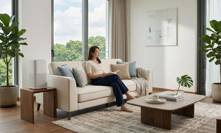 Air purifier placed on a side table beside a cream sofa in a bright Singapore living room.