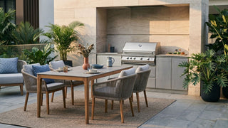 Outdoor BBQ pit with dining table, woven chairs, lounge seating and tropical plants in a Singapore patio setting.
