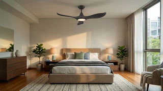 Bedroom ceiling fan with warm integrated light above a cosy bed, wooden furniture, plants, and natural window light