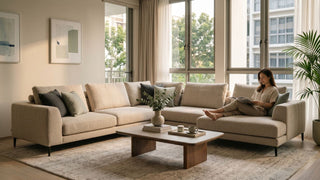 Beige sectional sofa in a bright Singapore condo living room with coffee table, large windows, and neutral decor