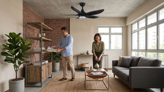 Black ceiling fan with light in an Italian-inspired industrial living room with white brick wall and wood coffee table