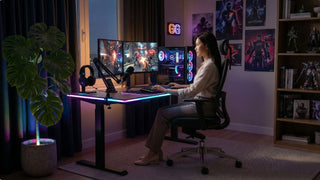 Woman using a black ergonomic office chair in a RGB gaming room with dual monitors, microphone, and gaming decor