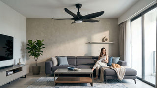 Black industrial ceiling fan with light in a modern Singapore condo living room with grey sofa, balcony windows and pet-friendly seating