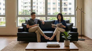 Couple relaxing on a black leather sofa in a warm Singapore maisonette living room