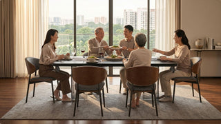 Multi-generation family sharing dinner at a black rectangular dining table in a warm Singapore condo dining room
