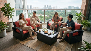 Friends relaxing on a black wicker outdoor lounge set with coral cushions on a condo balcony