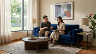 Blue fabric sofa styled in a bright Singapore living room with coffee table, rug and indoor plants