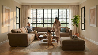 Brown sofa and ottoman in a spacious Singapore living room with baby, pet cat, coffee table, and soft natural light