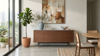 Wooden buffet cabinet with stone top styled beside a dining table in a bright Singapore apartment.