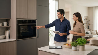 Couple reviewing a built-in oven in a modern Singapore kitchen before choosing the right oven for their home.