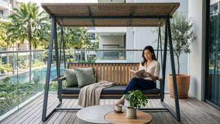 Woman relaxing on a canopy outdoor garden swing on a Singapore condo balcony with pool view and plants