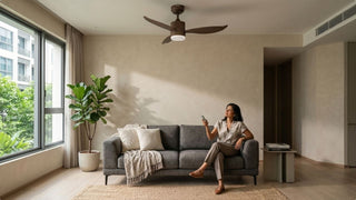Woman using a ceiling fan remote control in a modern Singapore living room with grey sofa