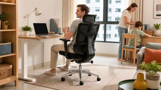 Black ergonomic mesh desk chair in a bright Singapore HDB home office with a family using the study corner.