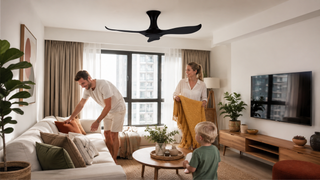 Black commercial ceiling fan in a bright modern Singapore living room with a family arranging the seating area.