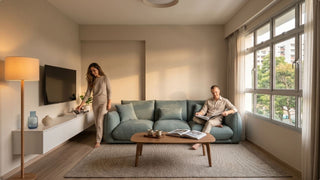 Blue 4 seater couch styled in a compact Singapore apartment with neutral walls, TV console and warm natural light