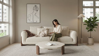 Woman relaxing with a cat on a cream sofa in a cosy Singapore living room with soft neutral decor