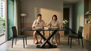 Couple enjoying dinner at a black dining set in a warm modern Singapore dining area