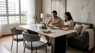 Couple enjoying a meal at a couch dining table with grey chairs and sofa seating in a Singapore home
