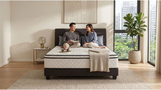 Couple relaxing on a Princebed mattress in a modern Singapore bedroom with neutral rug and large window