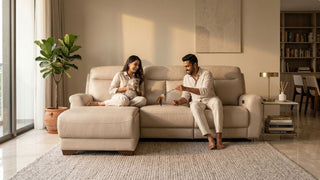Couple enjoying a beige reclining sofa with a cat in a warm modern Singapore home