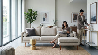 Couple relaxing with a cream chaise sofa in a modern Singapore living room with warm accents