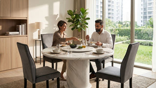 Couple sharing a meal at a round marble dining table in a warm Singapore home with grey chairs and garden view