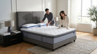 Couple arranging pillows on a super king mattress in a modern Singapore bedroom