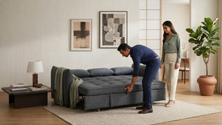 Couple testing a grey foldable sofa bed in a modern Singapore living room