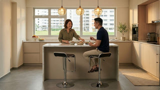 Couple using chrome bar stools at a bright kitchen island in a Singapore home