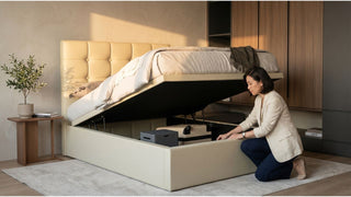 Cream gas lift storage bed in a compact Singapore bedroom with built-in wardrobe and hidden underbed storage