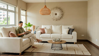 Man reading beside a cream sofa set in a bright Singapore home with warm modern styling