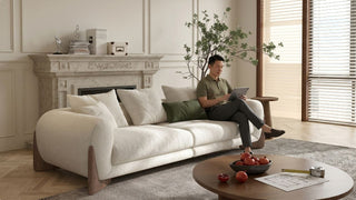 Man using a tablet on a cream sofa in a spacious Executive Condo living room with round coffee table