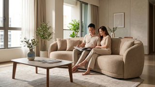 Couple relaxing on a modern curved sofa in a bright Singapore condominium living room with minimalist décor.