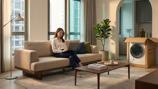Woman contacting support after a damaged washing machine delivery in a Singapore condo living room