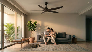 Dark ceiling fan in a modern Singapore living room with young family, baby, grey sofa, balcony plants, and warm light