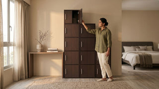 Woman using a dark tall cabinet in a compact Singapore home with bedroom nearby