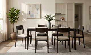 Dark wood dining chairs with beige seats around a rectangular dining table in an open-plan Singapore home.