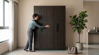 Woman checking a dark wood wardrobe in a modern Singapore bedroom before furniture replacement or disposal