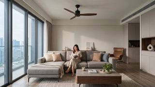 Modern Singapore condo living room with a DC ceiling fan, grey sofa, wooden coffee table, and natural daylight.