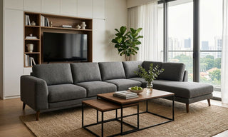 Grey sectional sofa in a modern Singapore condo living room with built-in TV storage, nesting coffee tables and balcony daylight.