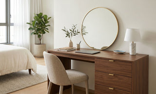 Wooden dresser study table with round mirror, drawers, laptop, lamp and chair in a calm modern bedroom.