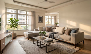 Executive flat living room in Singapore with L-shaped sofa, TV console, coffee table, rug, and warm natural lighting.