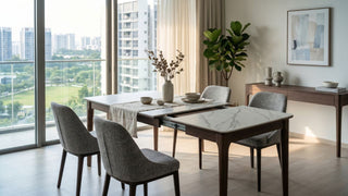 Extendable marble-look dining table with grey chairs in a bright Singapore condo dining room.