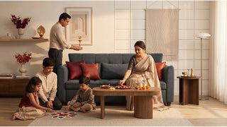 Family preparing for Deepavali in a modern Singapore living room with a grey sofa and coffee table