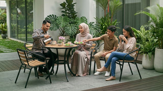Family using garden table and chairs on a lush Singapore outdoor patio