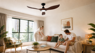 Dark wood ceiling fan with integrated light in a bright modern Singapore living room with a family relaxing below