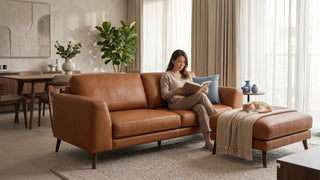 Faux leather sofa in a Singapore living room with a woman reading and a cat resting nearby.