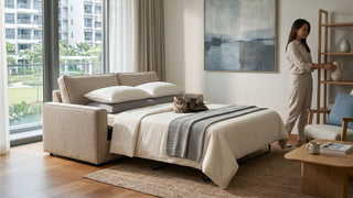 Foldable sofa bed opened as a guest bed in a Singapore condo living room with neutral decor and wooden shelving.