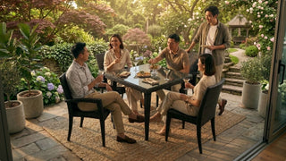 Friends gathering around a black wicker garden table with drinks and snacks in a warm outdoor garden patio